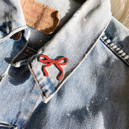 AC00489 Red Wispy Enamel Bow Pin, Pearlized Blush Pink - Cute Coquette Pins - Royalcore Balletcore Accessories - Ballet Bow Pin - Wildflower + Co Scale on denim jacket.