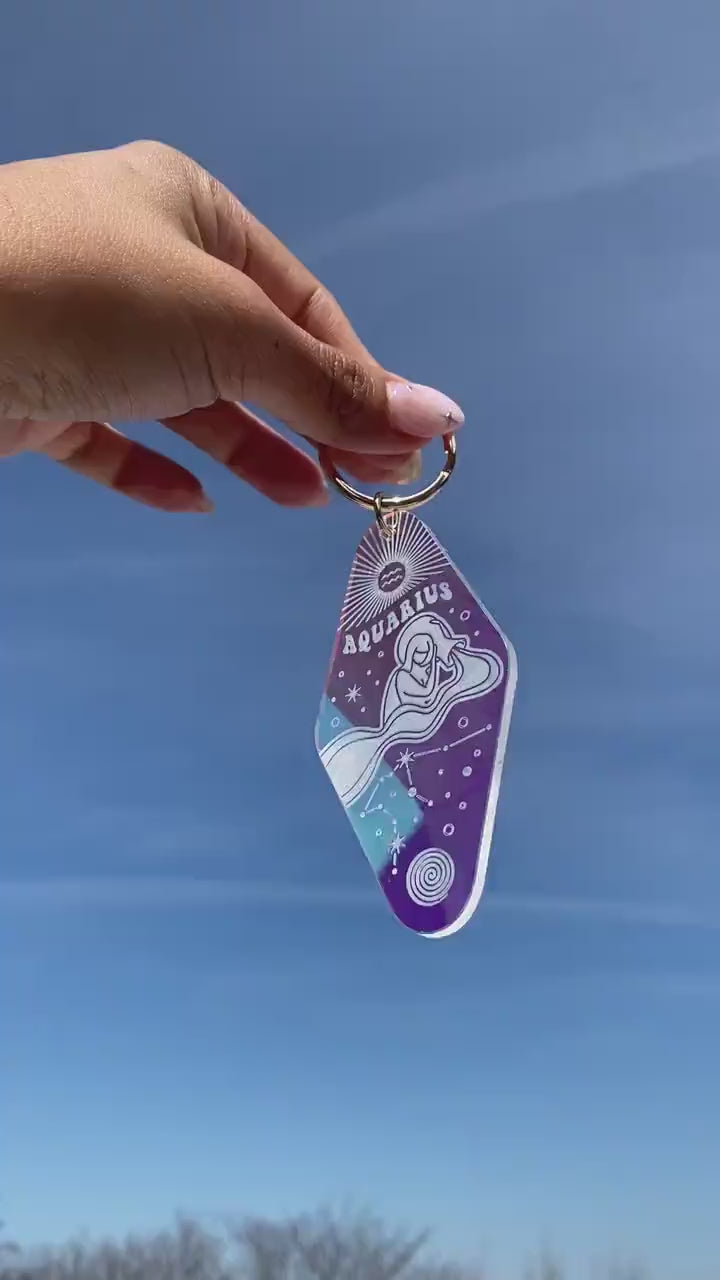 Zodiac Motel Keychains - Iridescent - Wildflower + Co. VIDEO against sky