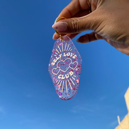 self love club glitter motel keychain in hand